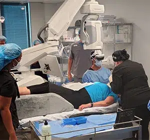 Doctors and nurses operating advanced surgical equipment and diagnostic tools during a patient procedure