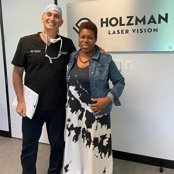 Dr. Holzman smiling with two happy patients who meet the over 18 age requirement to qualify for LASIK at Holzman Laser Vision